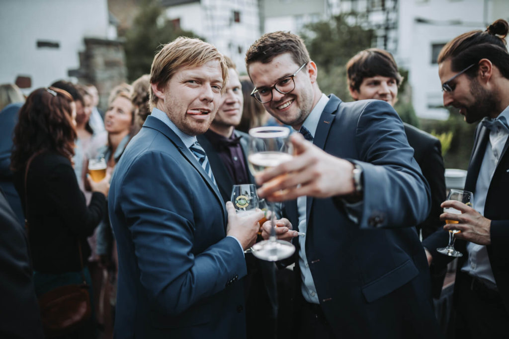 Zwei Hochzeitsgäste zeigen in die Kamera und machen dabei mit dem Fotografen Faxen